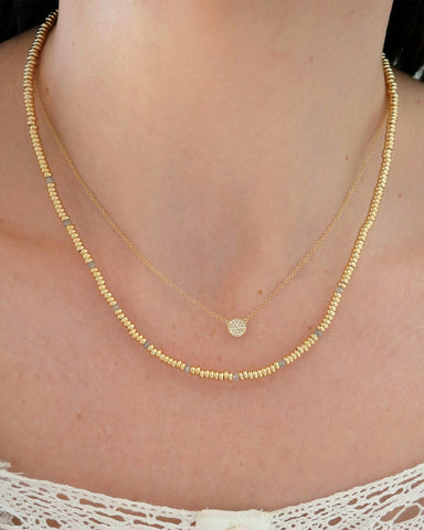 Birthstone Bead Necklace In Diamond in 14k yellow gold styled on neck of model with diamond disc necklace