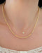 Birthstone Bead Necklace In Diamond in 14k yellow gold styled on neck of model with diamond disc necklace