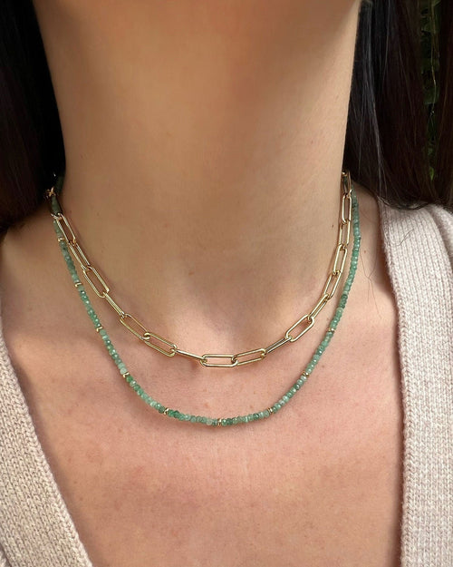 Birthstone Bead Necklace In Emerald styled on neck with 14k yellow gold jumbo chain necklace and wearing tan sweater
