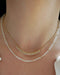 Birthstone Bead Necklace In Moon Stone styled on neck of model with gold and diamond segment necklace