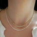 Birthstone Bead Necklace In Moon Stone styled on neck of model with gold and diamond segment necklace
