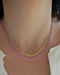 Birthstone Bead Necklace In Pink Sapphire styled on neck with diamond and gold ball necklace wearing a white blouse