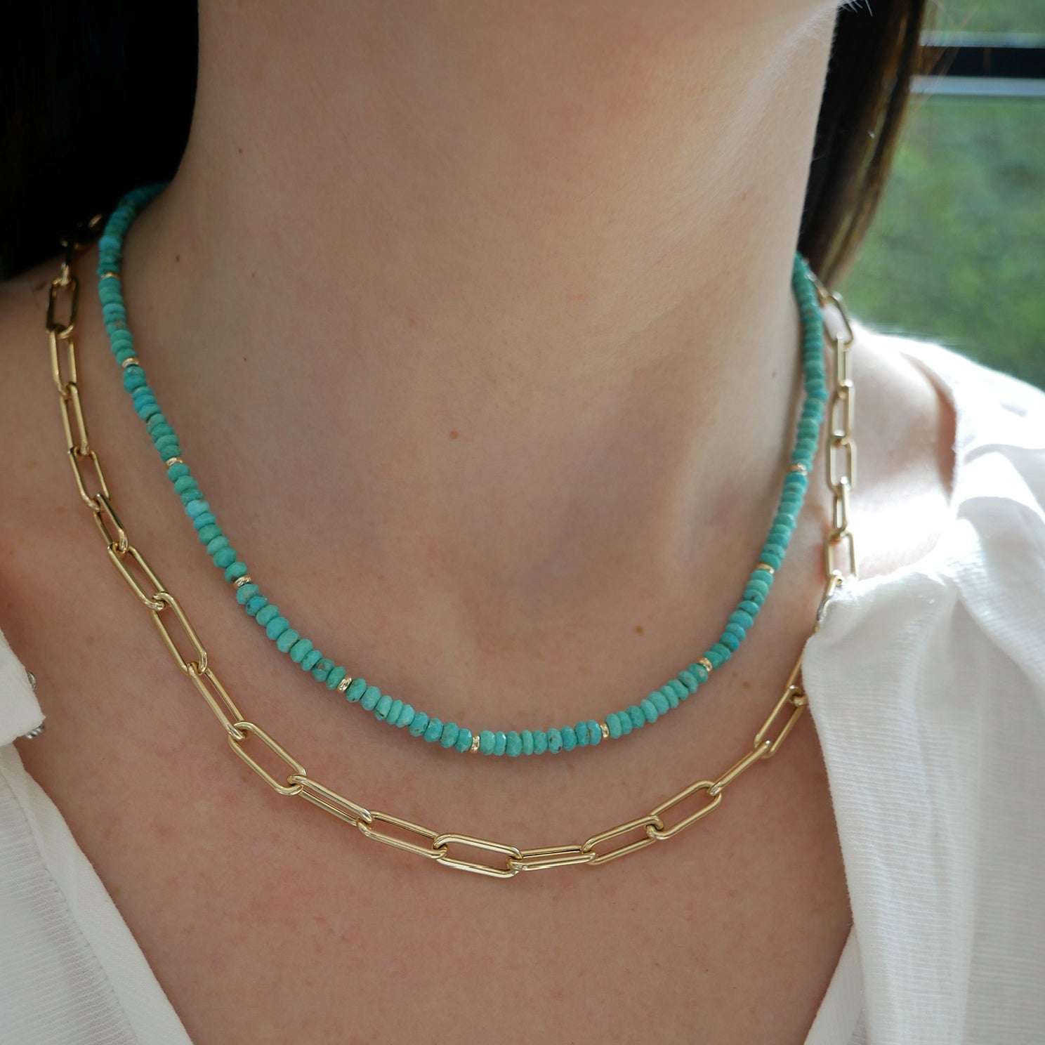 Birthstone Bead Necklace In Turquoise styled on neck of model wearing gold lola chain necklace