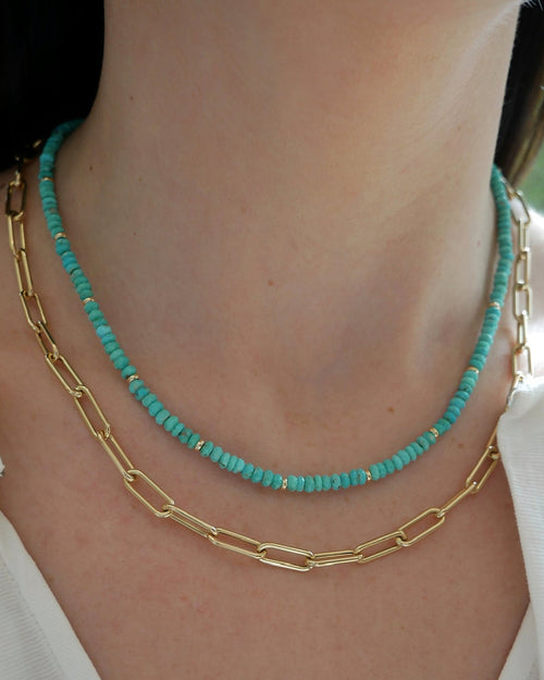 Birthstone Bead Necklace In Turquoise styled on neck of model wearing gold lola chain necklace