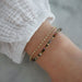 Birthstone Bead Bracelet In Tourmaline styled on wrist of model wearing diamond marquise bracelet and white sleeve