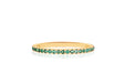 14k (karat) yellow gold band measuring 1.5 mm in width with precious emerald gemstones encircling.
