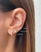 Jumbo Solitaire Diamond Stud Earring in 14k yellow gold styled on second earring hole on ear lobe of model with three other earrings