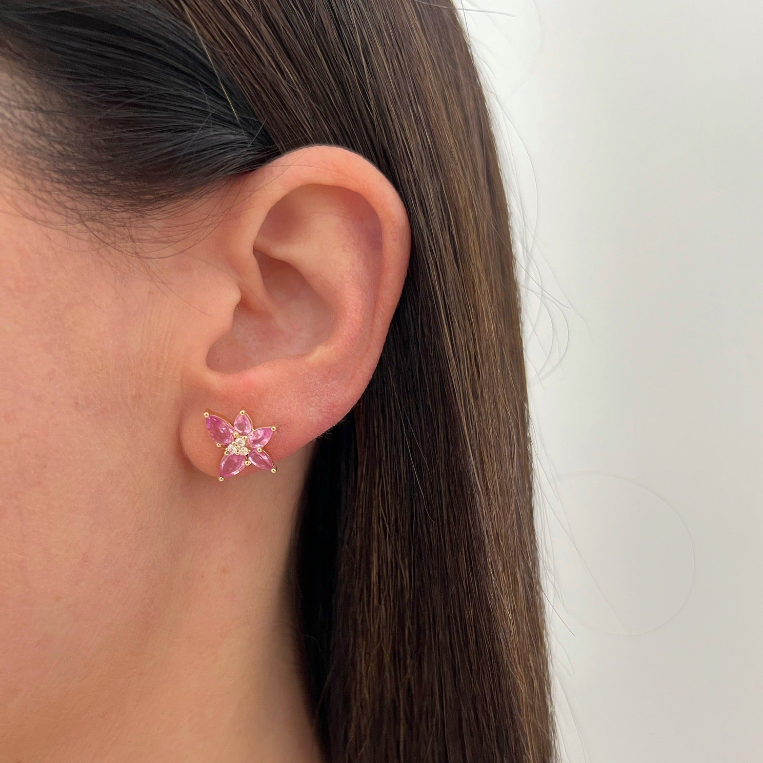 Pink Sapphire & Diamond Trio Cluster Stud Earring in 14k yellow gold styled on ear lobe of model with brown hair
