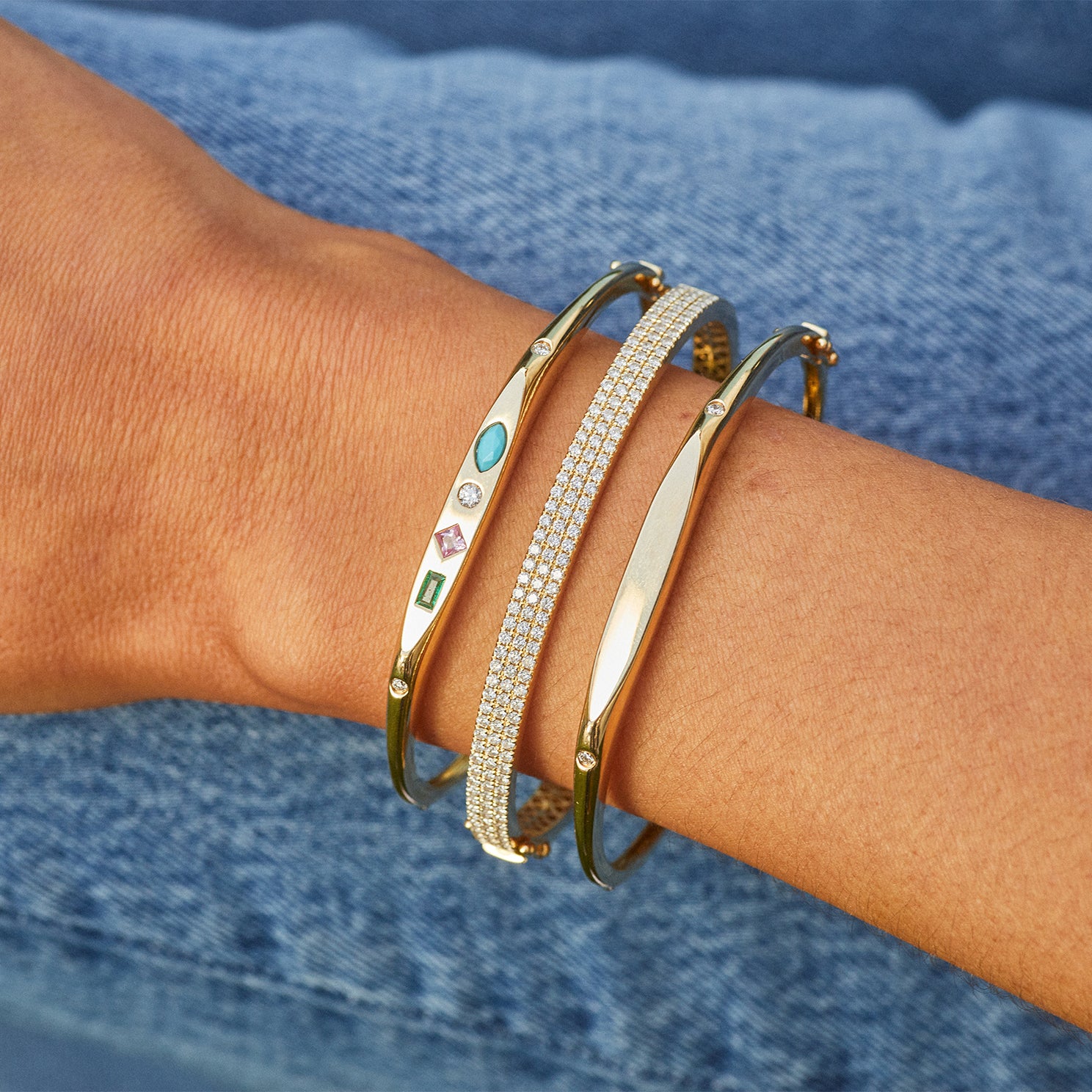 Gold Treasure Bangle in 14k yellow gold styled on wrist of model with diamond bangle bracelet and gold bangle bracelet styled on wrist of model