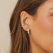 Triple Treasure Stud Earring in 14k yellow gold styled on second earring hole on earlobe of model styled with diamond hoop earring, diamond stud earring, and diamond cuff earring