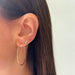 Double Treasure Stud Earring in 14k yellow gold on second earring hole on earlobe of model wearing gold hoop and pink baguette stud earring