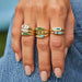 Diamond and Emerald Treasure Ring in 14k yellow gold styled on index finger, middle finger, and ring finger of model styled with five additional rings