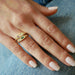 Diamond and Pink Sapphire Treasure Ring in 14k yellow gold styled on ring finger of model and stacked with emerald treasure ring