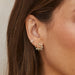 Diamond Blossom Stud Earring in 14k yellow gold styled on ear of model next to huggie and white quartz earring