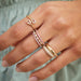 White Quartz Double Pear Ring in 14k yellow gold styled on index finger of model next to five stacked rings on other fingers