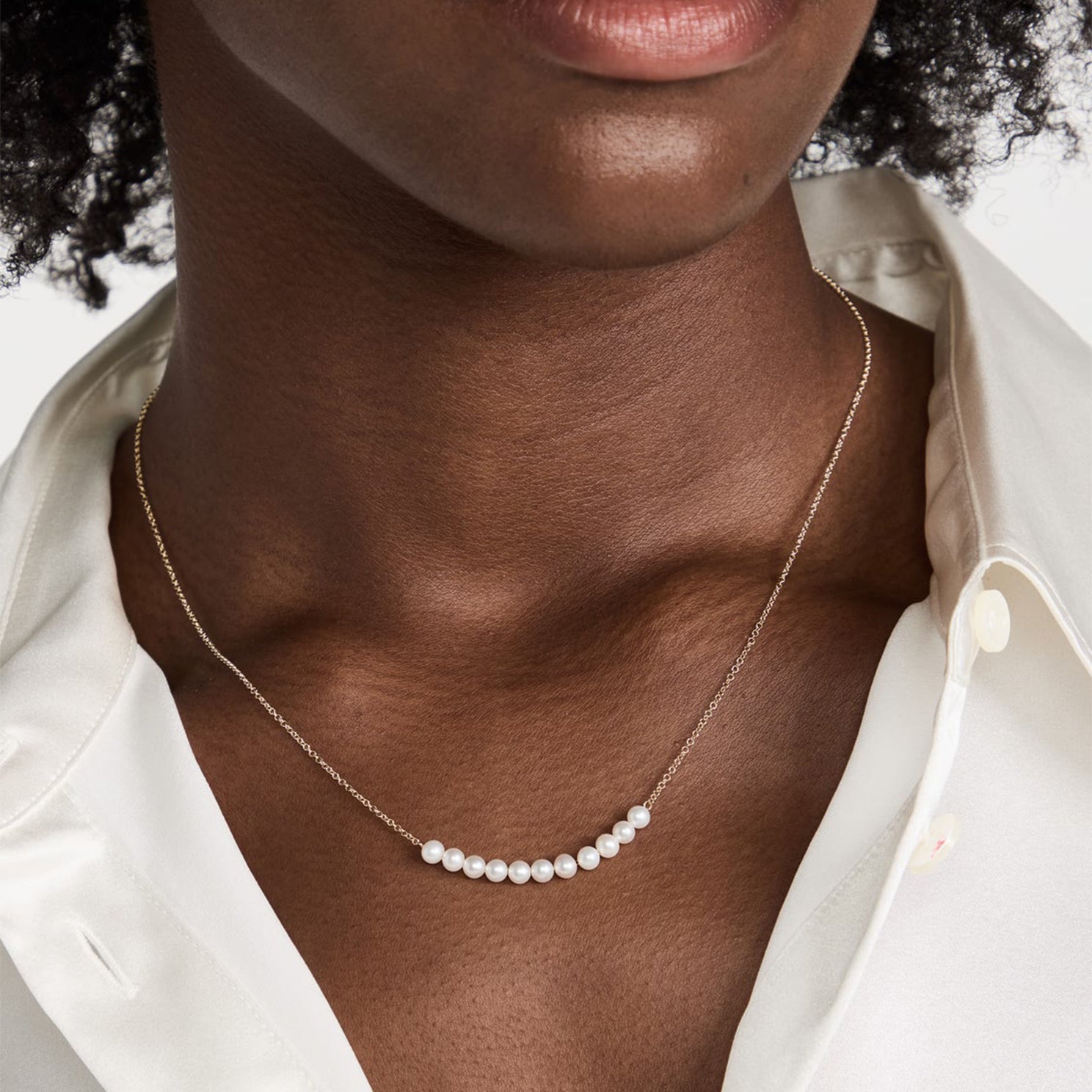 Pearl Necklace in 14k yellow gold styled on neck of model wearing white blouse