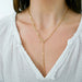 Graduated Chain Link Lariat Necklace in 14k yellow gold styled on neck of model wearing white blouse