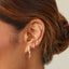 Marquise Diamond Mini Huggie Earring in 14k yellow gold styled on second earring hole of model with brown hair