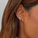 Double Diamond Baguette Illusion Mini Huggie Earring in 14k yellow gold styled on ear of model