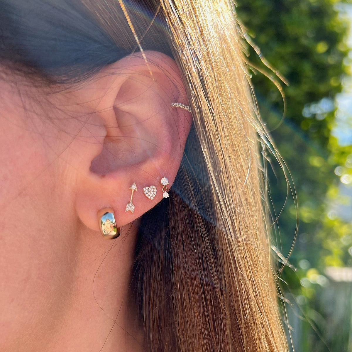 Gold Bubble Huggie Earring in 14k yellow gold styled on ear with brown hair