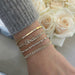 Diamond Script Name Curb Chain Bracelet on the wrist in yellow gold