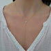 Full Cut Diamond Teardrop Lariat Necklace in 14k yellow gold styled on neck of model wearing white blouse