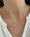 Baby Diamond Star And Gold Moon Necklace in 14k yellow gold styled with diamond burst necklace styled on neck of model