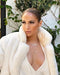 Pavé Diamond Hummingbird Necklace in 14k yellow gold with diamond birthstone eye styled on neck of model wearing white fur coat