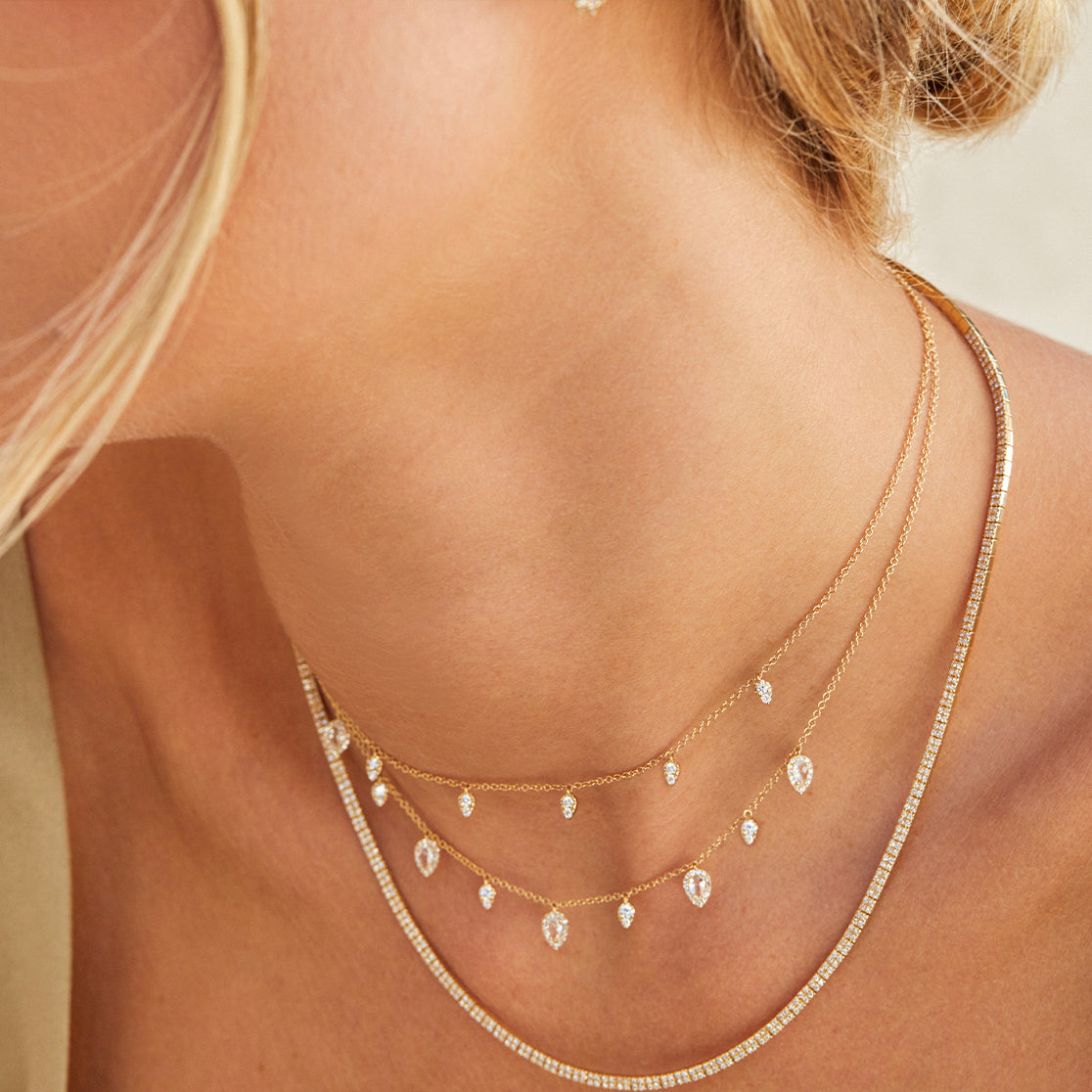 Diamond & White Quartz Ultimate Teardrop NecklaceDiamond & White Quartz Ultimate Teardrop Necklace in 14k yellow gold styled on neck of model with additional teardrop necklace and diamond segment necklace
