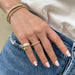 Gold and Diamond Jumbo Double Dome Ring in 14k yellow gold styled on pinky ring finger of model next to gold ball ring and model wearing two bracelets