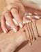Endless Love Eternity Bracelet in 14k rose gold styled on wrist of model with diamond bracelets and rose gold rings styled on fingers of model