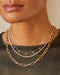 Diamond Grace Necklace styled on neck of model with layered necklaces and model in black blouse