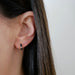 Diamond Black Enamel Huggie Earring in 14k yellow gold styled on ear lobe of model