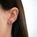 Diamond Navy Enamel Huggie Earring in 14k yellow gold styled next to evil eye stud earring on ear lobe of model