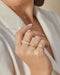 diamond, gold, and enamel rings styled on fingers of model