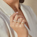 diamond, gold, and enamel rings styled on fingers of model