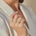 3 Diamond & White Enamel Stack Ring in 14k yellow gold styled on finger of model with diamond rings