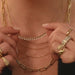 Diamond & Gold Ball Necklace being held in between fingers of model wearing 14k yellow gold layered necklaces and 14k yellow gold rings with no audio