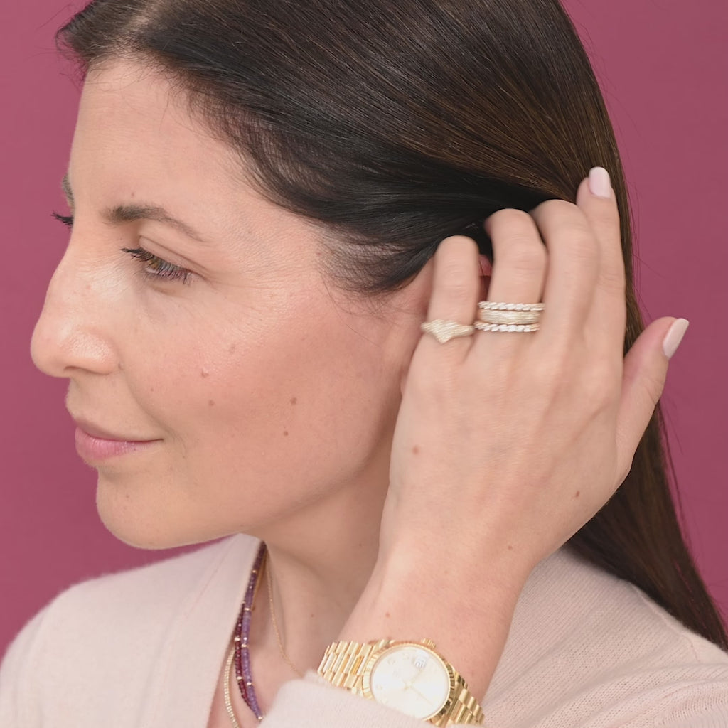 model wearing diamond lola huggie earring in second hole of earring styled with three hoop earrings with no audio