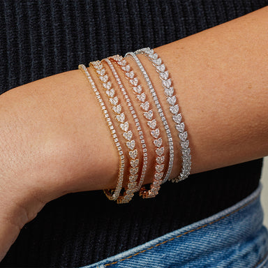 Endless Love Eternity Bracelet styled on the wrist in white gold, rose gold, and yellow gold, styled next to diamond tennis bracelets