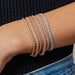 Endless Love Eternity Bracelet styled on the wrist in white gold, rose gold, and yellow gold, styled next to diamond tennis bracelets