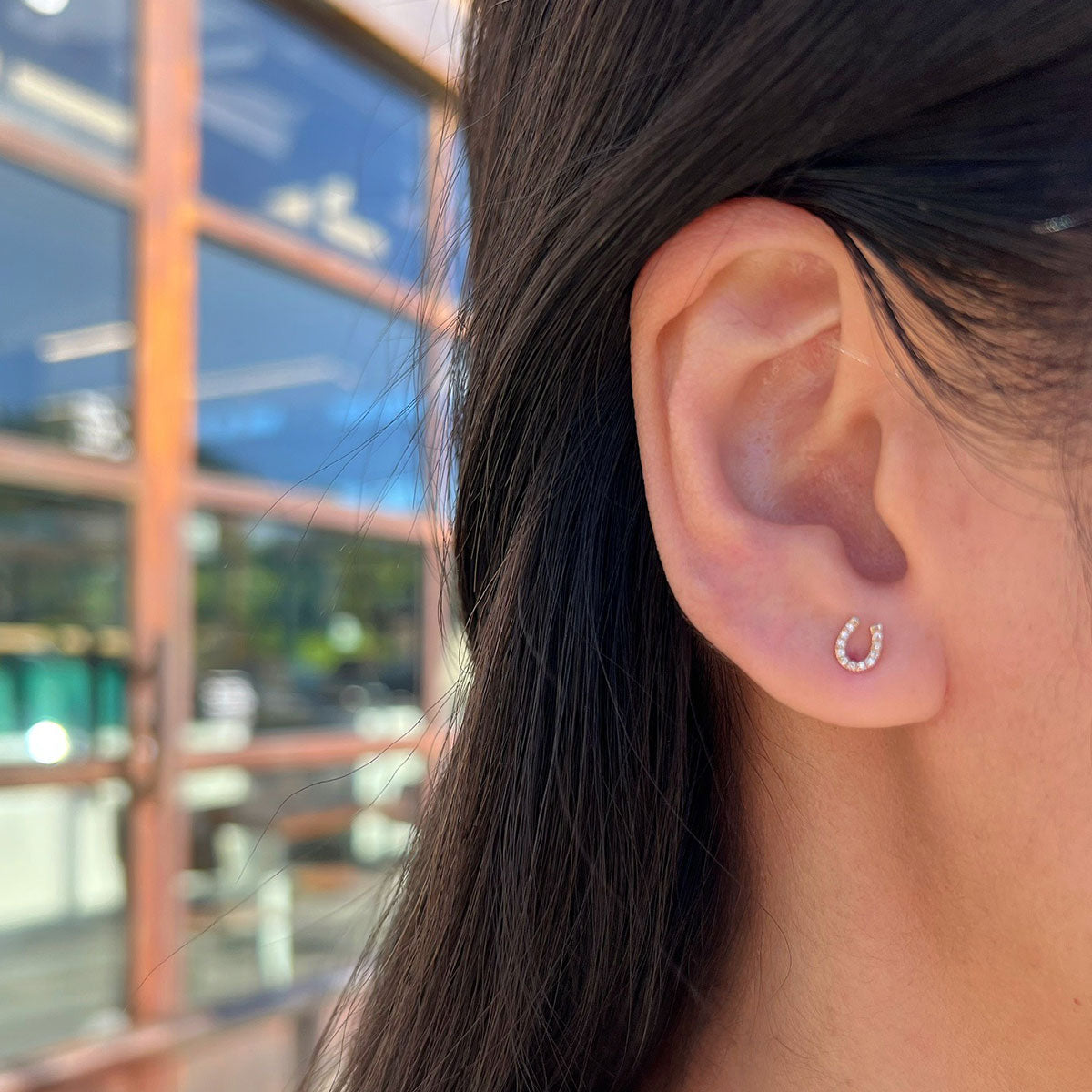 Horse Shoe Stud in 14k yellow gold styled on ear
