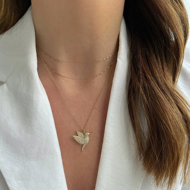 Pave Diamond Hummingbird Necklace styled on the neck in yellow gold 